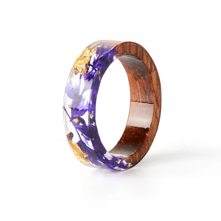 Holzring mit lila Blumen und Goldflocken, handgefertigt, einzigartiges Schmuckdesign.
