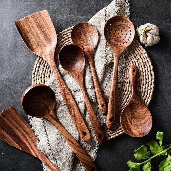 Holzlöffel-Set aus Akazienholz auf Leinentuch, Küchengeräte, rustikales Design, dunkles Holz.