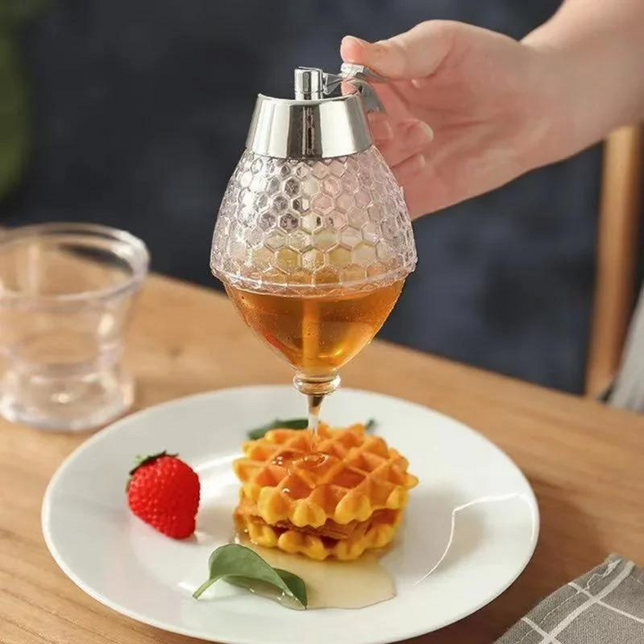 Honigspender aus Glas, Wabenmuster, gießt Honig auf Waffeln, Frühstück, Küche.