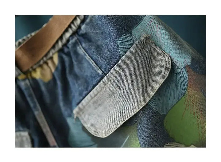 Nahaufnahme bunte Jeans mit Blumenmuster, brauner Gürtel, modische Damenbekleidung.