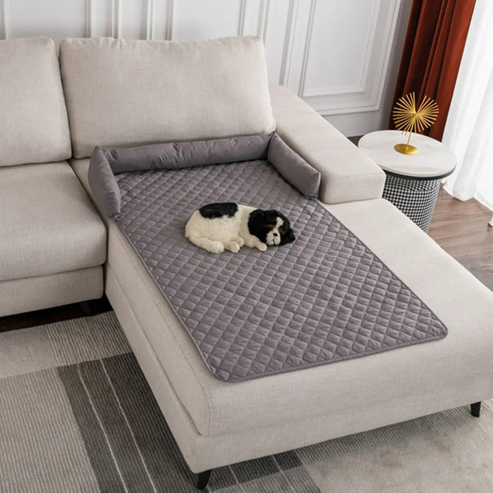 Graue gesteppte Sofaschutzdecke mit kleinem Hund, Wohnzimmer, Möbelpflege, Heimdekoration.