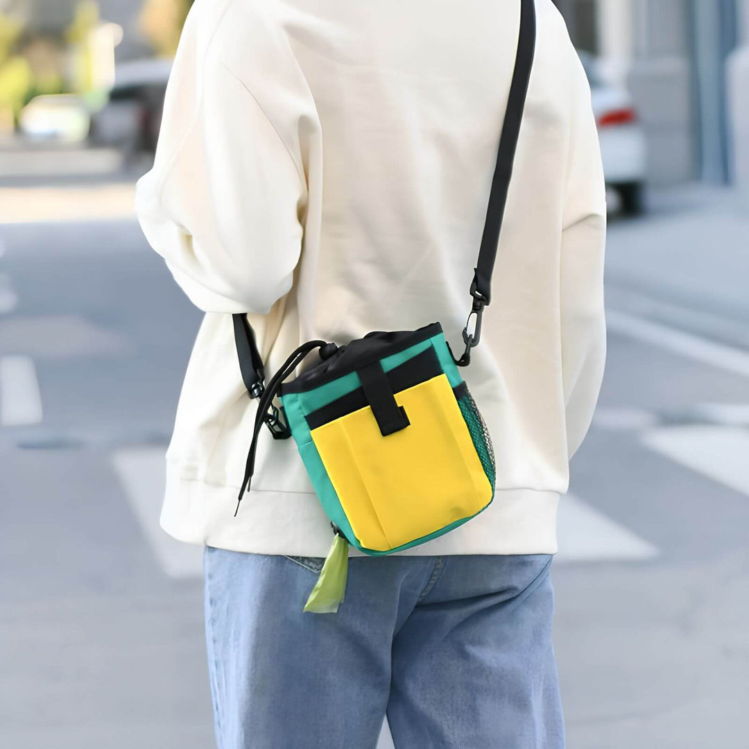 Person mit bunter Hundeleckerli-Tasche, praktisch für Training, unterwegs, Zubehör.