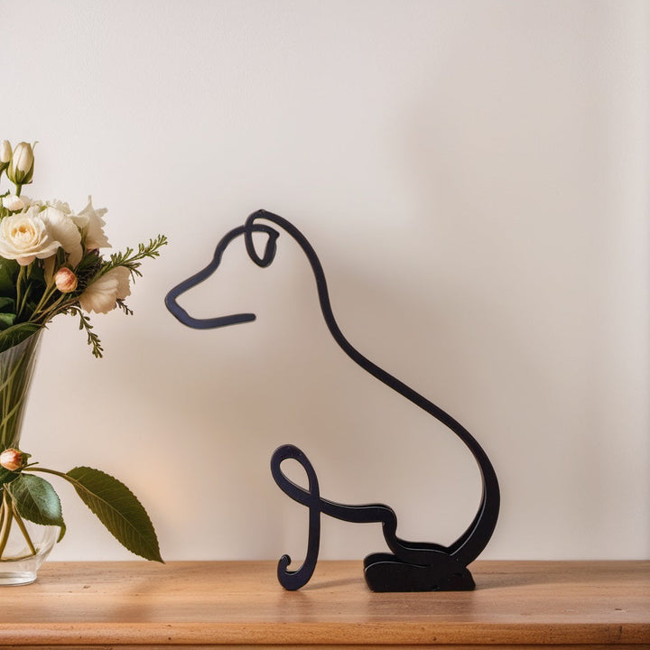 Schwarze Jack-Russell-Terrier-Skulptur aus Metall auf Holzregal neben Blumenstrauß.