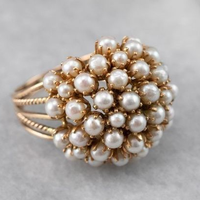 Goldener Ring mit weißen Perlen, elegantes Schmuckdesign, luxuriöses Accessoire für Damen.