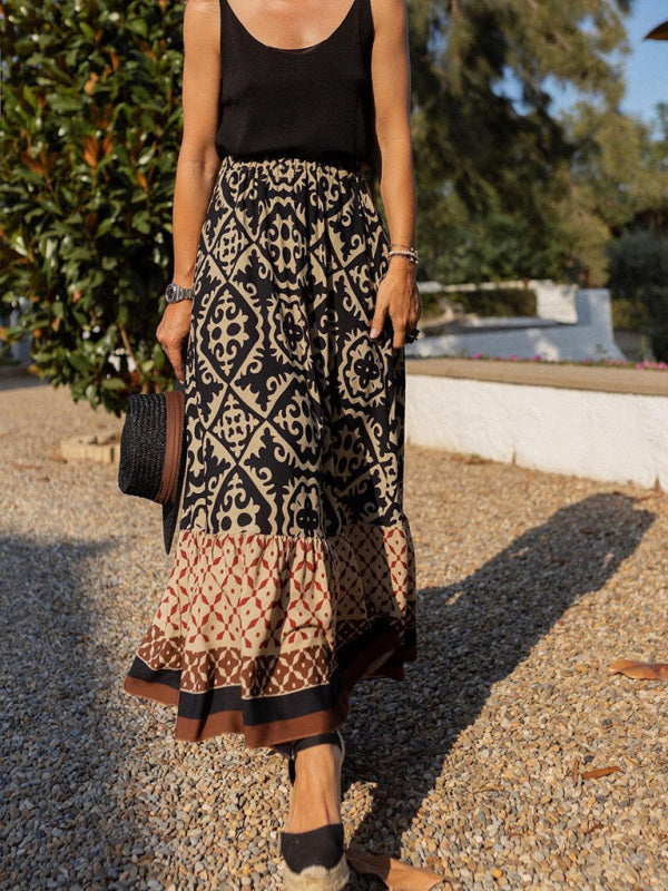 Frau in schwarzem Top und gemustertem Maxirock, Sommermode, draußen, eleganter Stil.