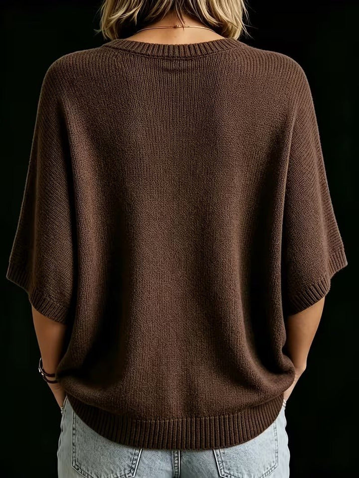 Hnědý pletený top s netopýřími rukávy a žebrovanými lemy, pohled zezadu na modelce v džínách. 21