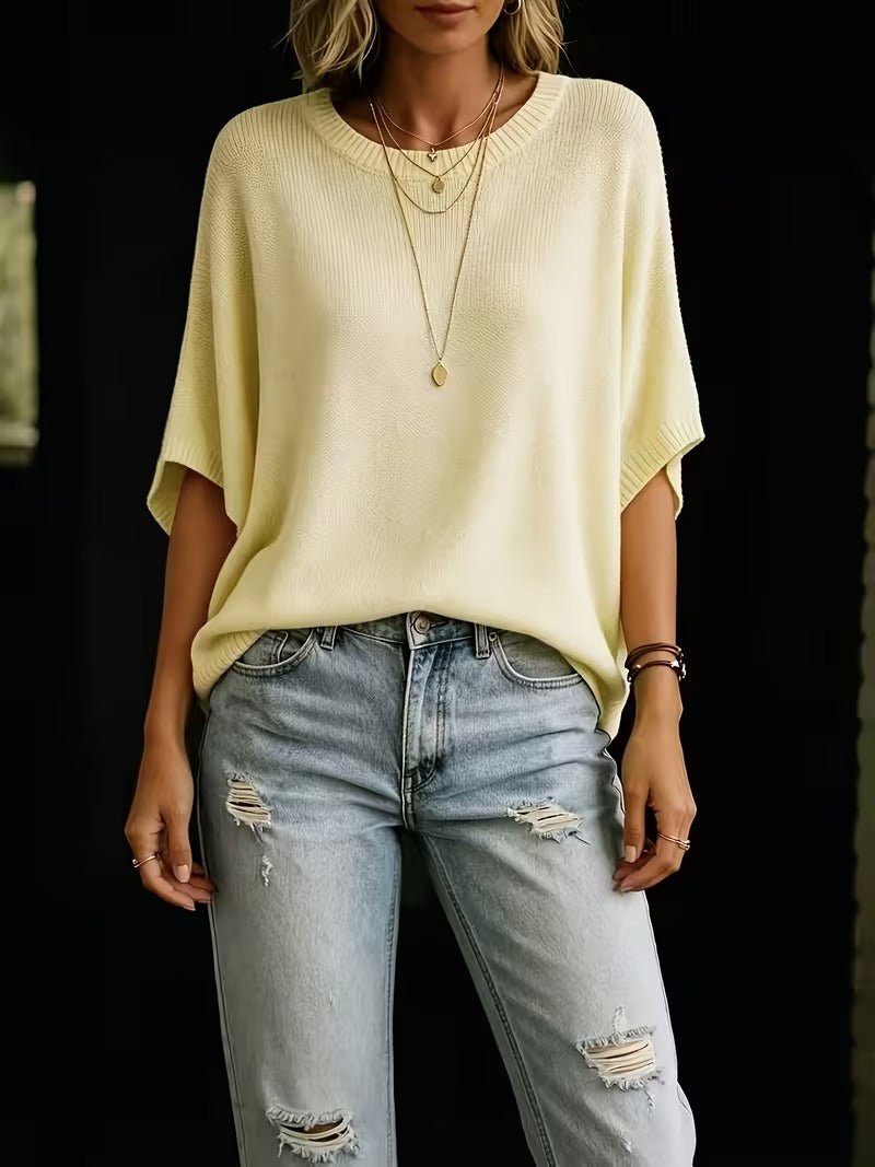 Světle žlutý volný pletený top na modelce v roztrhaných světlých džínách, pohled zepředu až po stehna. 5