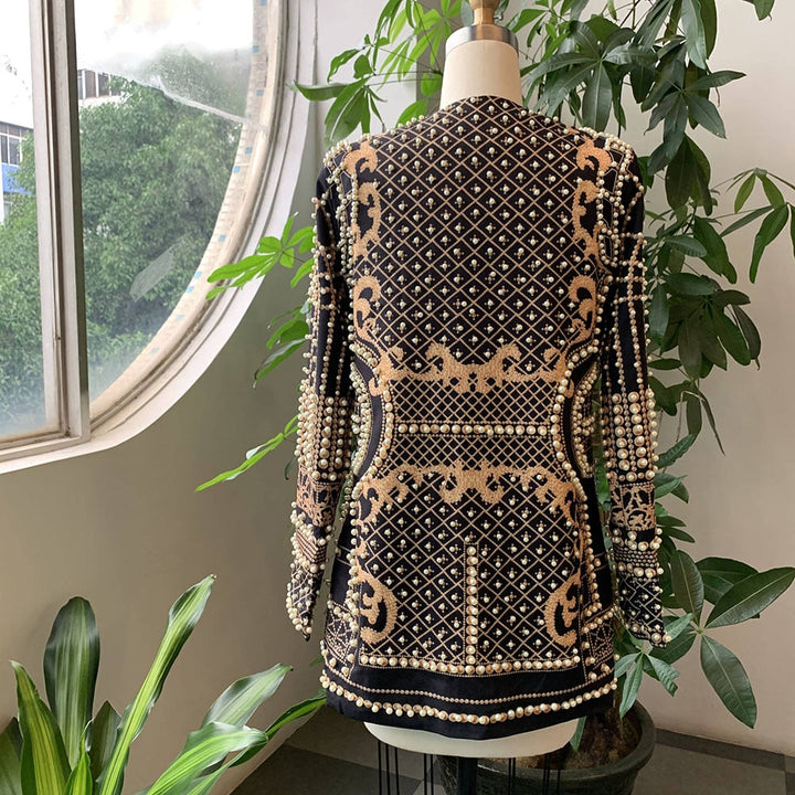 Schwarze Jacke mit goldenen Verzierungen, Perlenmuster, Damenmode, elegant, auf Schneiderpuppe.
