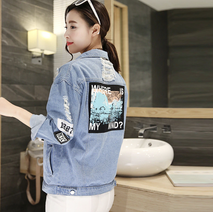 Frau in blauer Jeansjacke mit Aufdruck, Badezimmer, modisch, lässig, Streetwear.