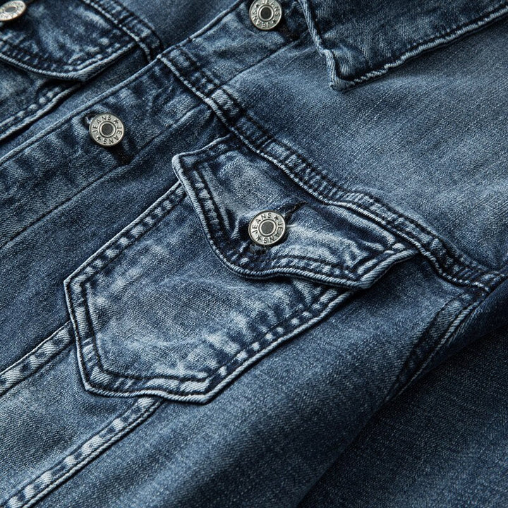 Nahaufnahme einer blauen Jeansjacke mit Taschen und silbernen Knöpfen, Denim-Textur.