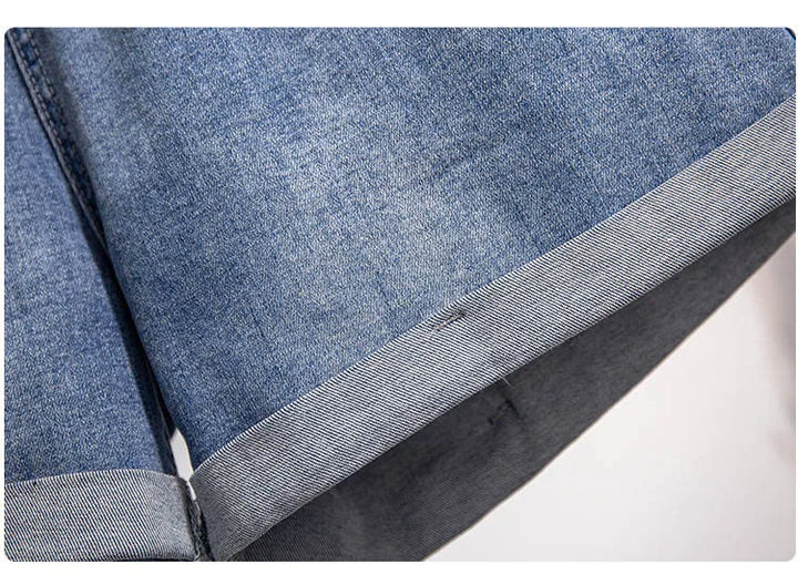 Nahaufnahme blauer Jeansstoff, Saumdetail, Denim, Mode, Textur, Bekleidungsmaterial.