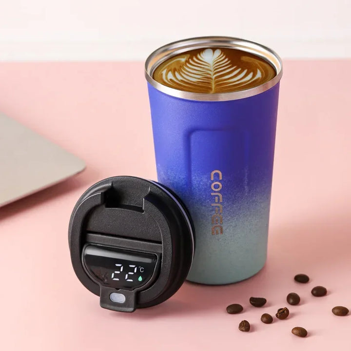 Blauer Thermobecher mit Temperaturanzeige, Latte Art Kaffee, Edelstahl, isoliert, modern.