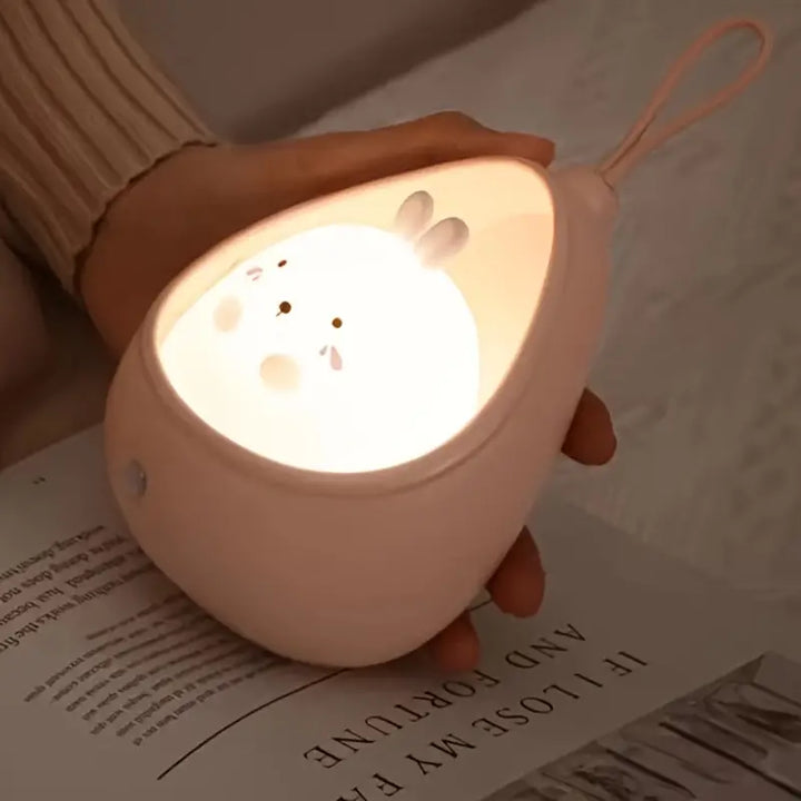 Rosa Nachtlicht in Tropfenform mit Hasenmotiv, tragbar, LED, Kinderzimmer, Hand gehalten.