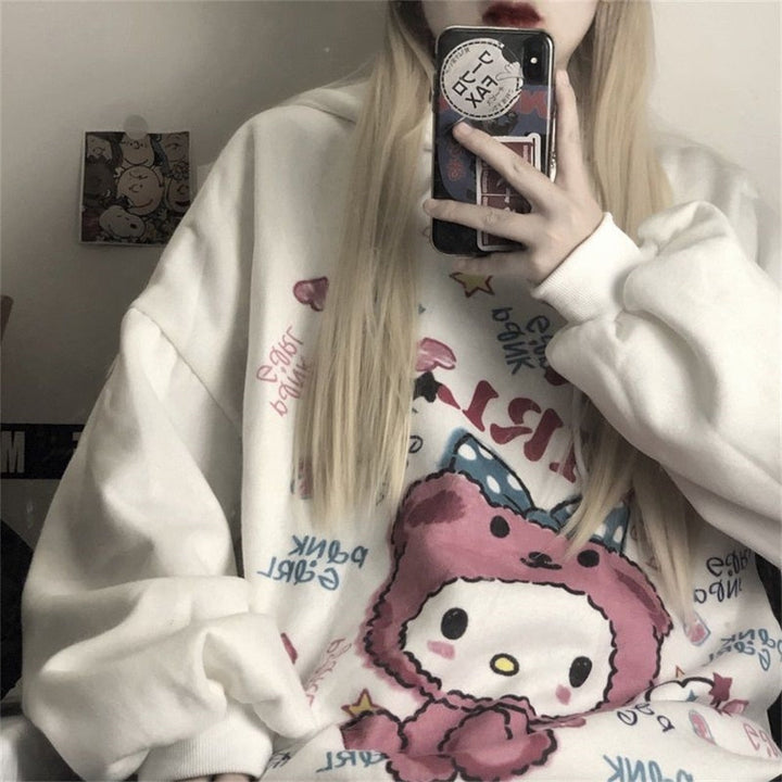 Frau in weißem Hello Kitty Pullover mit Smartphone, modisches Kawaii-Design, Selfie.