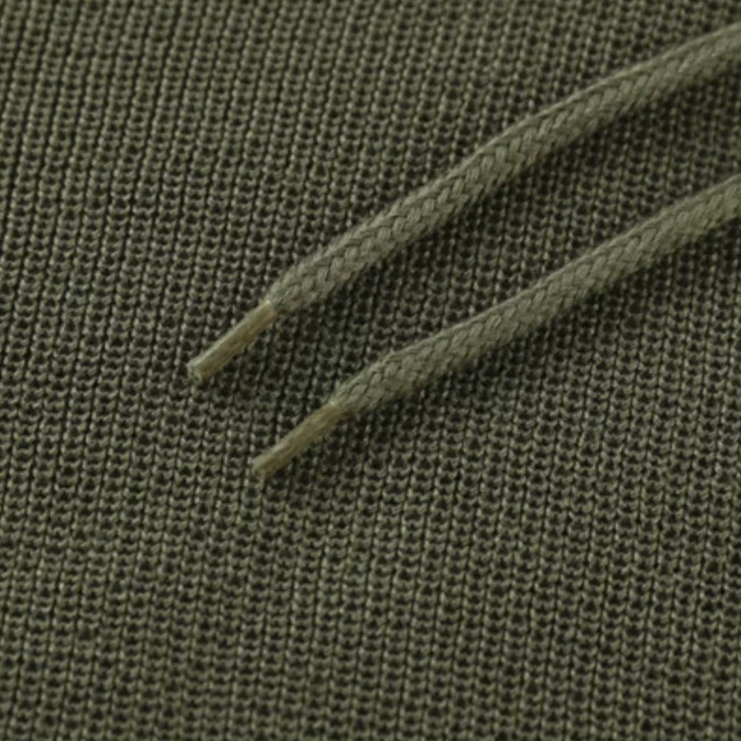 Grüner Baumwollstoff mit Kordelzug, Nahaufnahme, Textilstruktur, Mode, Bekleidungsmaterial.