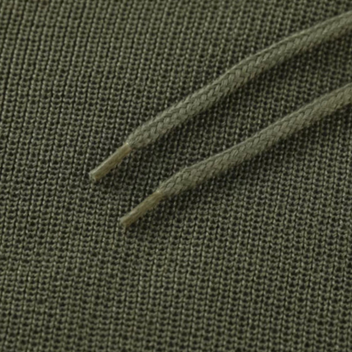 Grüner Baumwollstoff mit Kordelzug, Nahaufnahme, Textilstruktur, Mode, Bekleidungsmaterial.