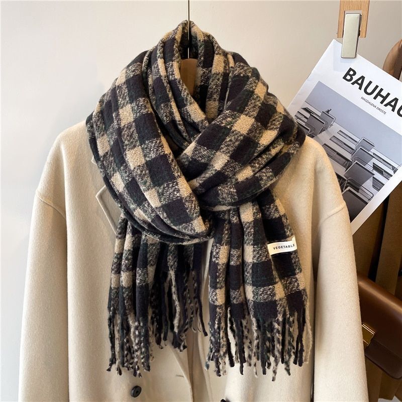 Schwarz-beiger karierter Wollschal auf beigem Mantel, modisch, warm, Winteraccessoire.