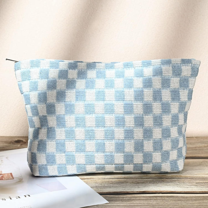 Hellblau-weiß karierte Kosmetiktasche aus Stoff auf Holztisch, stilvoll und praktisch.