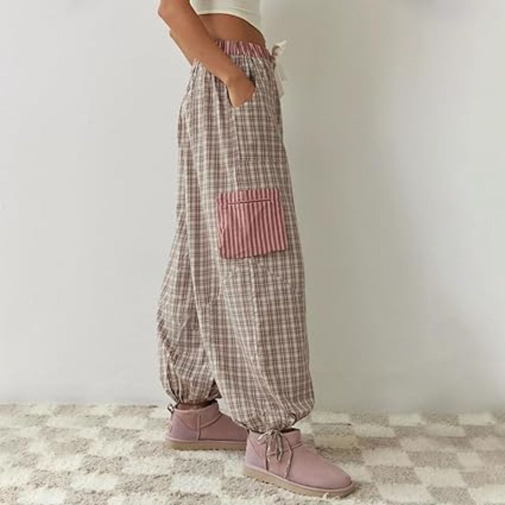 Frau in karierten Haremshosen mit rosa Tasche, lässige Mode, bequeme Damenbekleidung.