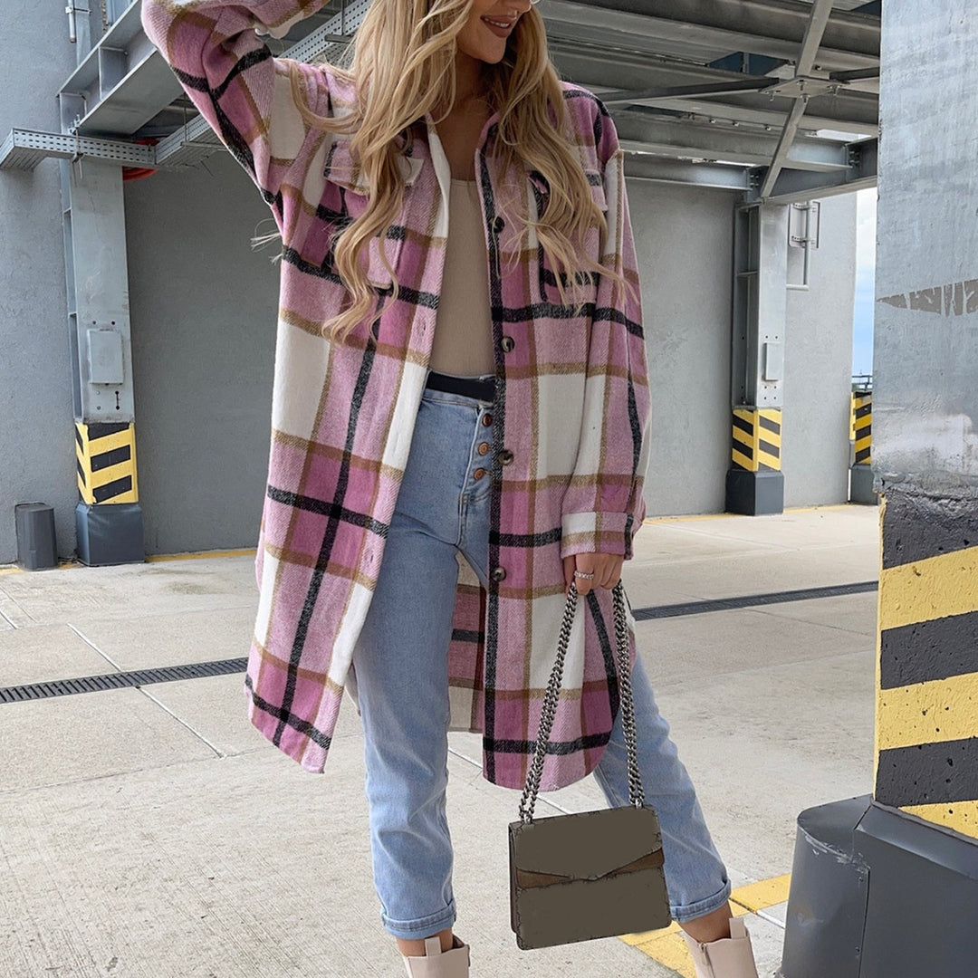 Frau in rosa kariertem Oversize-Hemd, Jeans und Stiefeln, hält eine graue Handtasche.