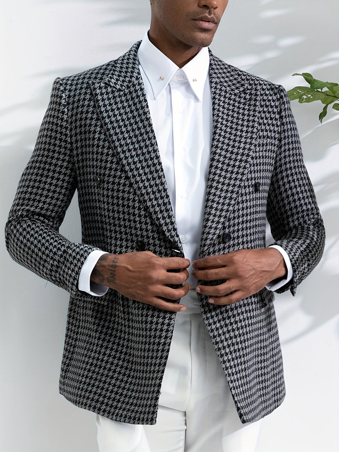 Mann im eleganten Hahnentritt-Sakko, schwarz-weiß, mit weißem Hemd, stilvolle Herrenmode.