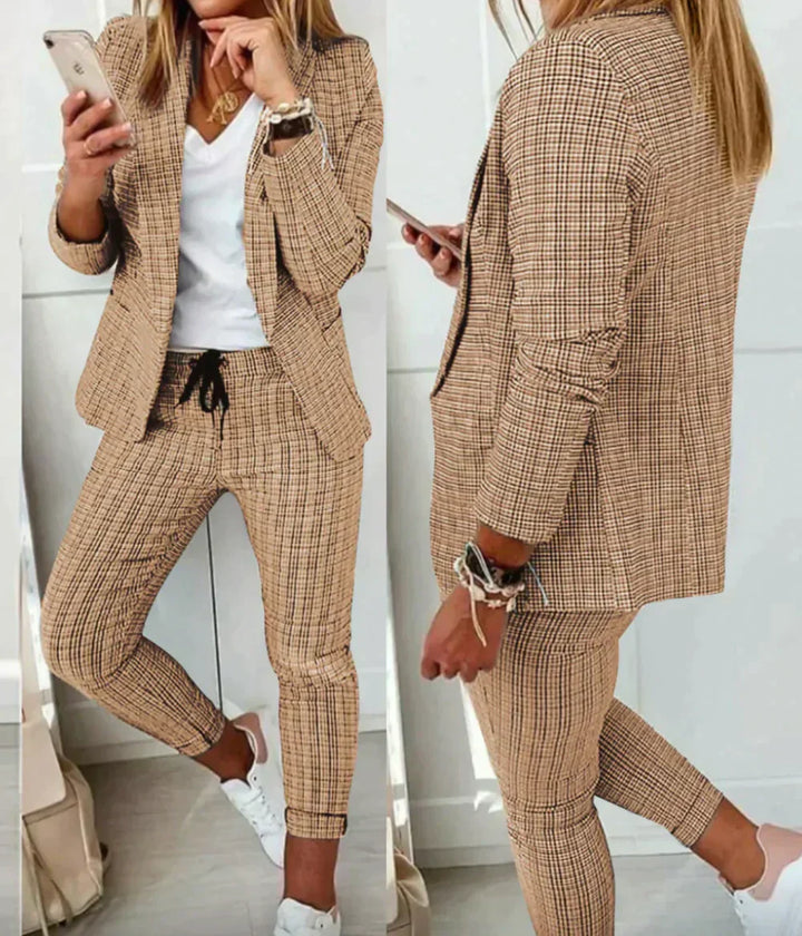 Frau im karierten Hosenanzug, beige, mit Smartphone, weißes T-Shirt, weiße Sneaker.