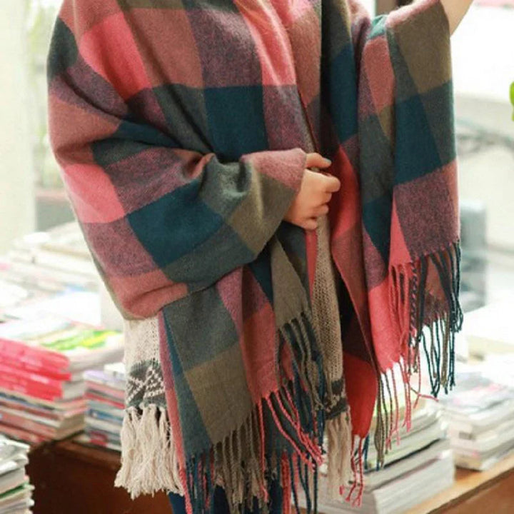 Frau mit kariertem Schal in Rosa und Grau, Fransen, weiches Material, modisches Accessoire.