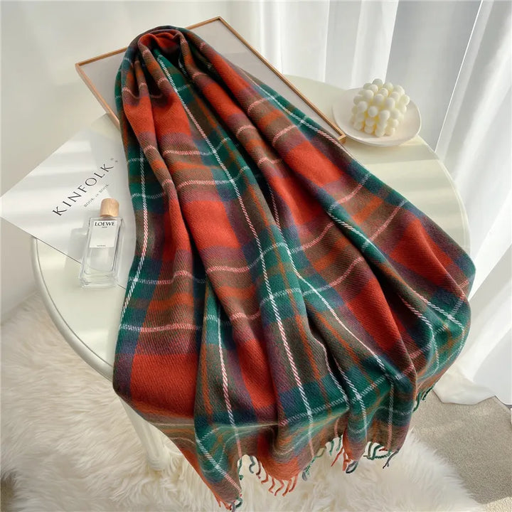 Karierter Wollschal in Rot-Grün auf Tisch, Herbstmode, weiches Material, stilvolles Accessoire.