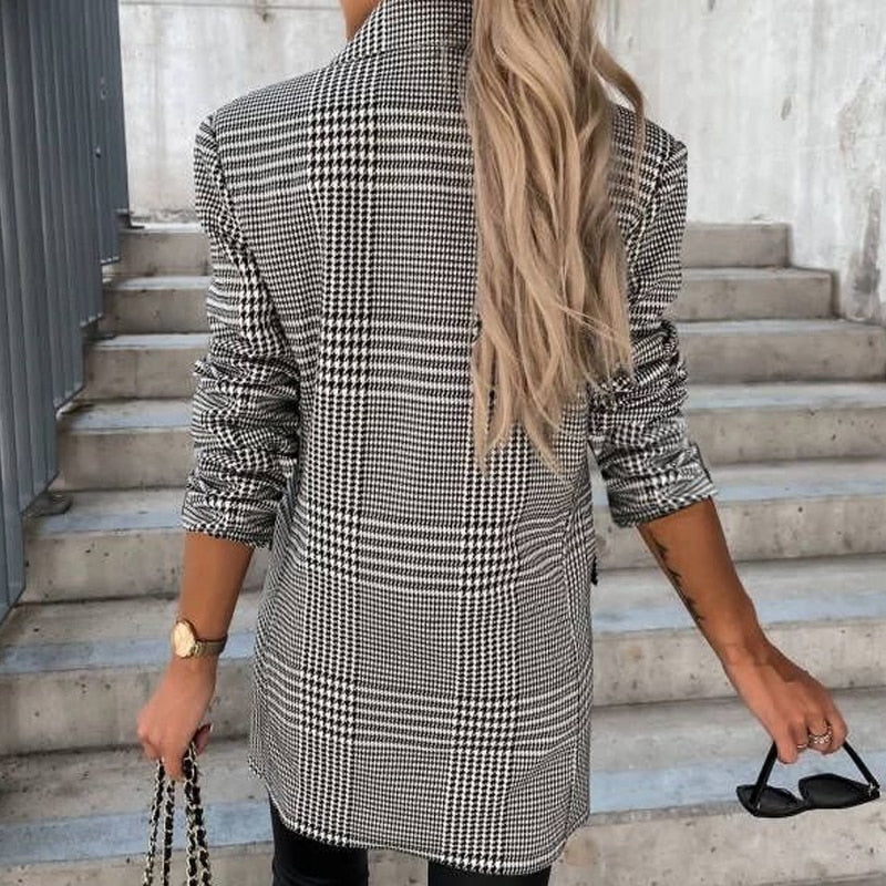 Frau im karierten Blazer, blonde Haare, Treppe, Sonnenbrille, modisch, stilvoll, Rückansicht.