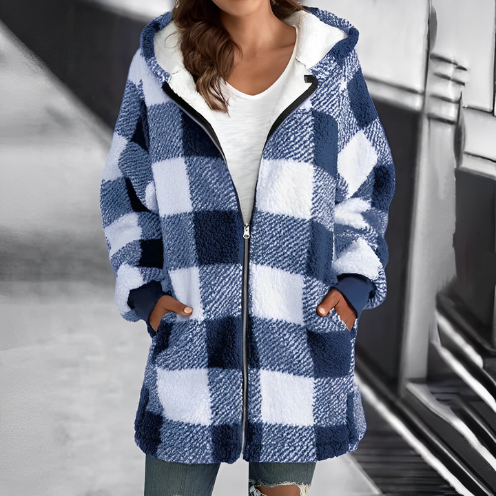 Frau in blau-weiß kariertem Fleece-Mantel, Reißverschluss, Kapuze, lässiger Winterlook.
