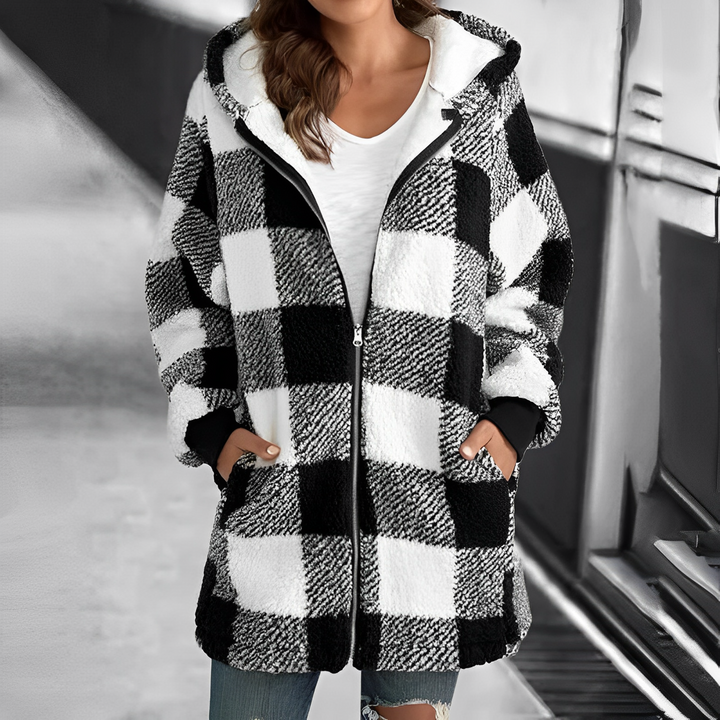 Frau in kariertem schwarz-weißem Fleece-Mantel mit Kapuze, Reißverschluss, Taschen, lässiger Stil.