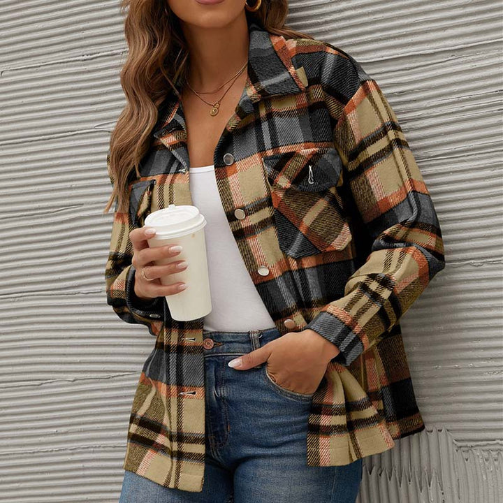 Frau in karierter Jacke, beige-schwarz, mit Kaffeebecher, lässige Mode, Herbstoutfit.