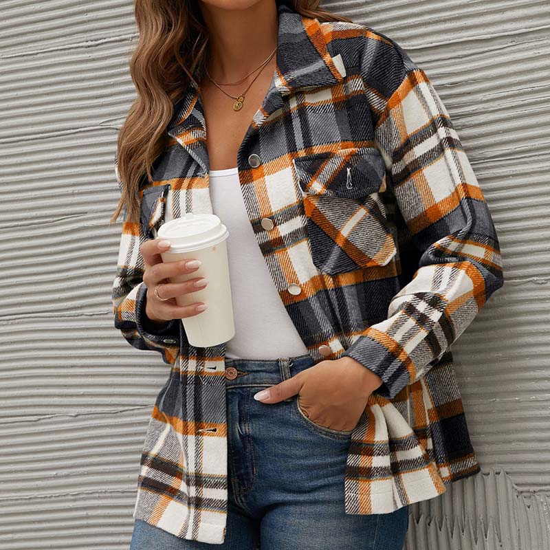Frau in karierter Jacke, hält Kaffeebecher, modische Herbstkleidung, Freizeitlook.