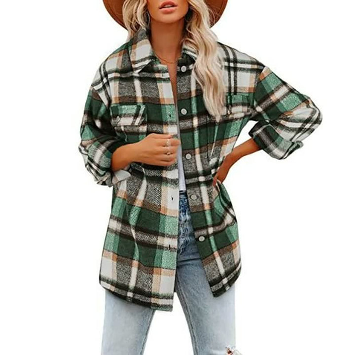 Frau in grün-kariertem Oversize-Hemd, Jeans und Hut, modischer Herbst-Look.