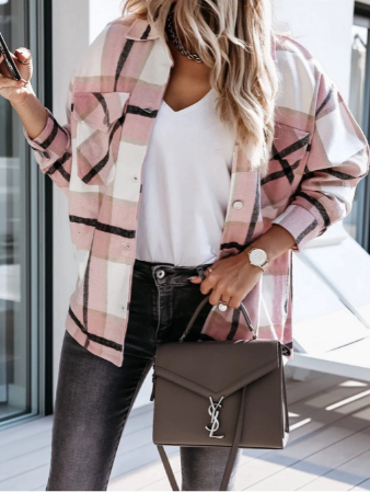 Frau in rosa kariertem Hemd, weißem T-Shirt, schwarzer Jeans, hält graue Designer-Handtasche.