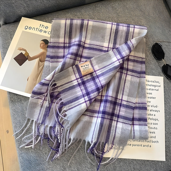 Lila-weiß karierter Schal aus Wolle auf grauem Sofa, modisches Accessoire, Herbst-Winter.