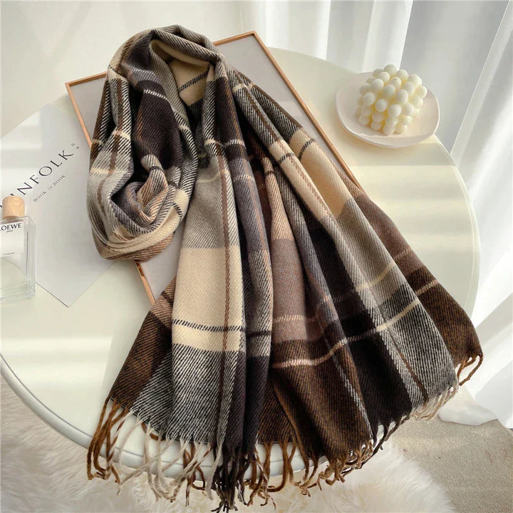 Kariertes Wollschal in Braun- und Beigetönen auf Tisch, modisches Accessoire für Herbst/Winter.