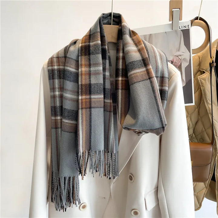 Grauer karierten Schal aus Wolle auf weißem Mantel, modisches Accessoire für Herbst und Winter.