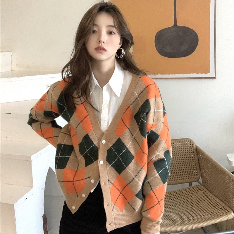 Frau trägt karierten Cardigan in Orange und Grün, Herbstmode, gemütlicher Strick, Damenbekleidung.