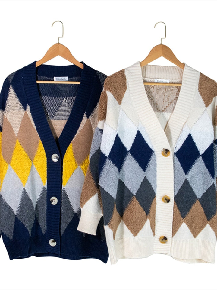 Zwei Strickjacken mit Rautenmuster, blau-gelb und beige-blau, auf Holzkleiderbügeln.