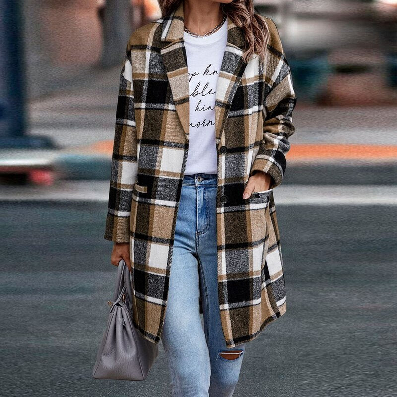 Frau in kariertem Mantel, Jeans und weißem T-Shirt, hält graue Handtasche, modisch, urban.