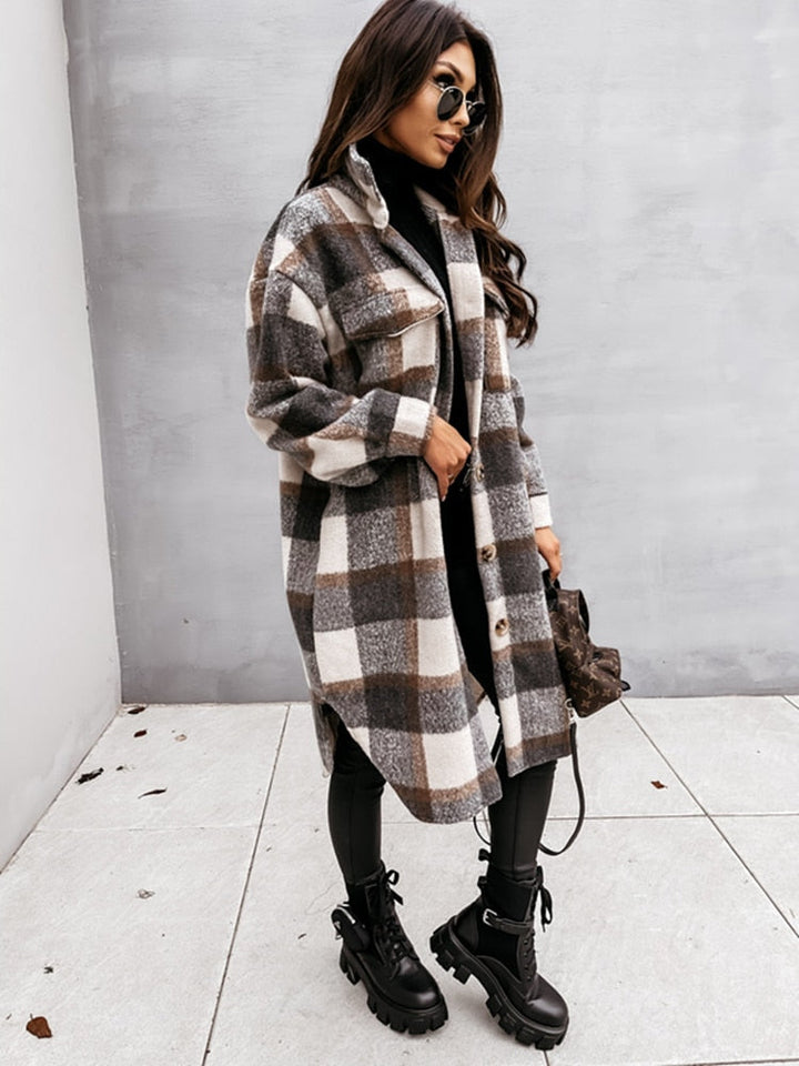 Frau in kariertem Oversize-Mantel, schwarze Stiefel, Sonnenbrille, modischer Herbst-Look.