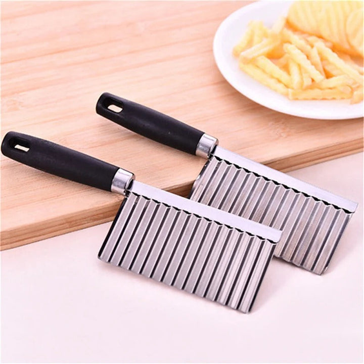 Zwei Edelstahl-Wellenschneider mit schwarzem Griff auf Holzbrett, ideal für Pommes.