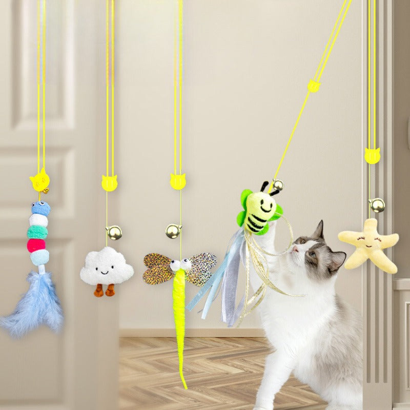 Katze spielt mit hängendem Katzenspielzeug, bunte Plüschtiere, interaktives Spielzeug.