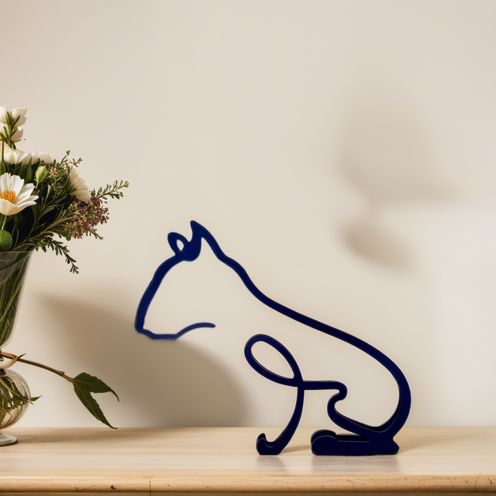 Blaue Katzenfigur aus Metall auf Holzregal, moderne Deko, neben Blumenstrauß.