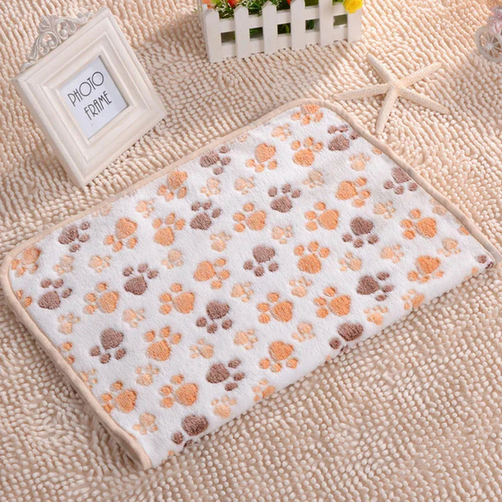 Weiße Fleece-Haustierdecke mit buntem Pfotenmuster, weich und warm, ideal für Katzen und Hunde.