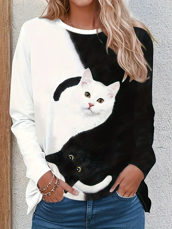 Frau trägt weißes Langarmshirt mit Yin-Yang-Katzenmotiv, lässiger Stil, Baumwolle.