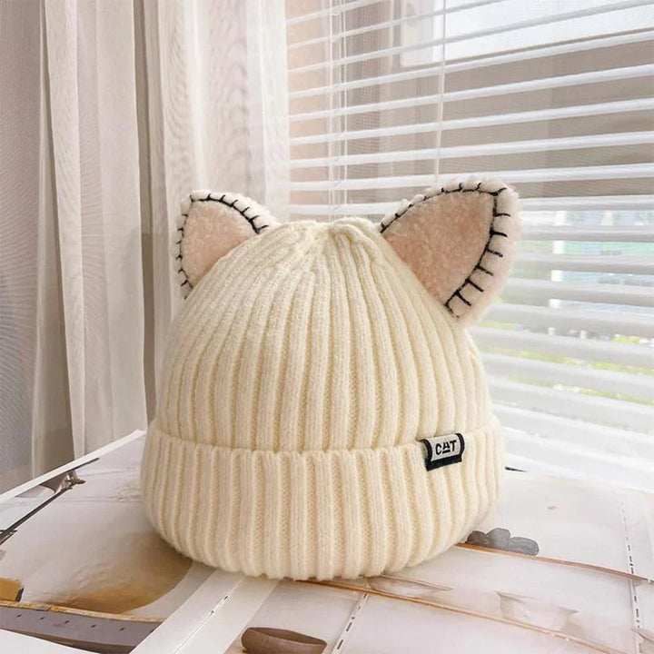 Weiße Strickmütze mit Katzenohren, Damenmode, Winteraccessoire, gemütlich, stilvoll.
