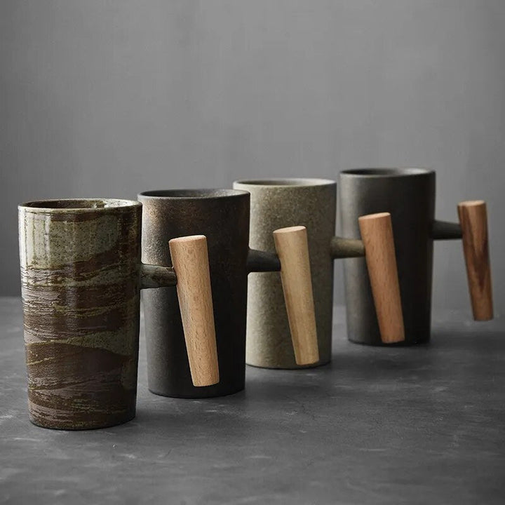 Vier Keramiktassen mit Holzgriffen, modern, minimalistisch, in Erdtönen auf grauem Hintergrund.