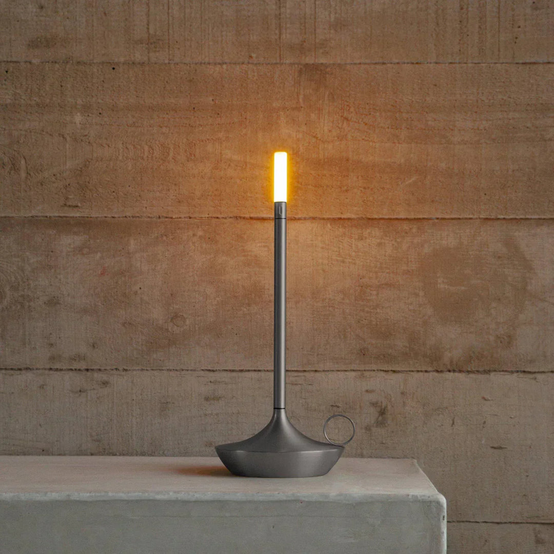 Moderne LED-Tischlampe, schlankes Design, graues Metall, warmweißes Licht, minimalistisch.